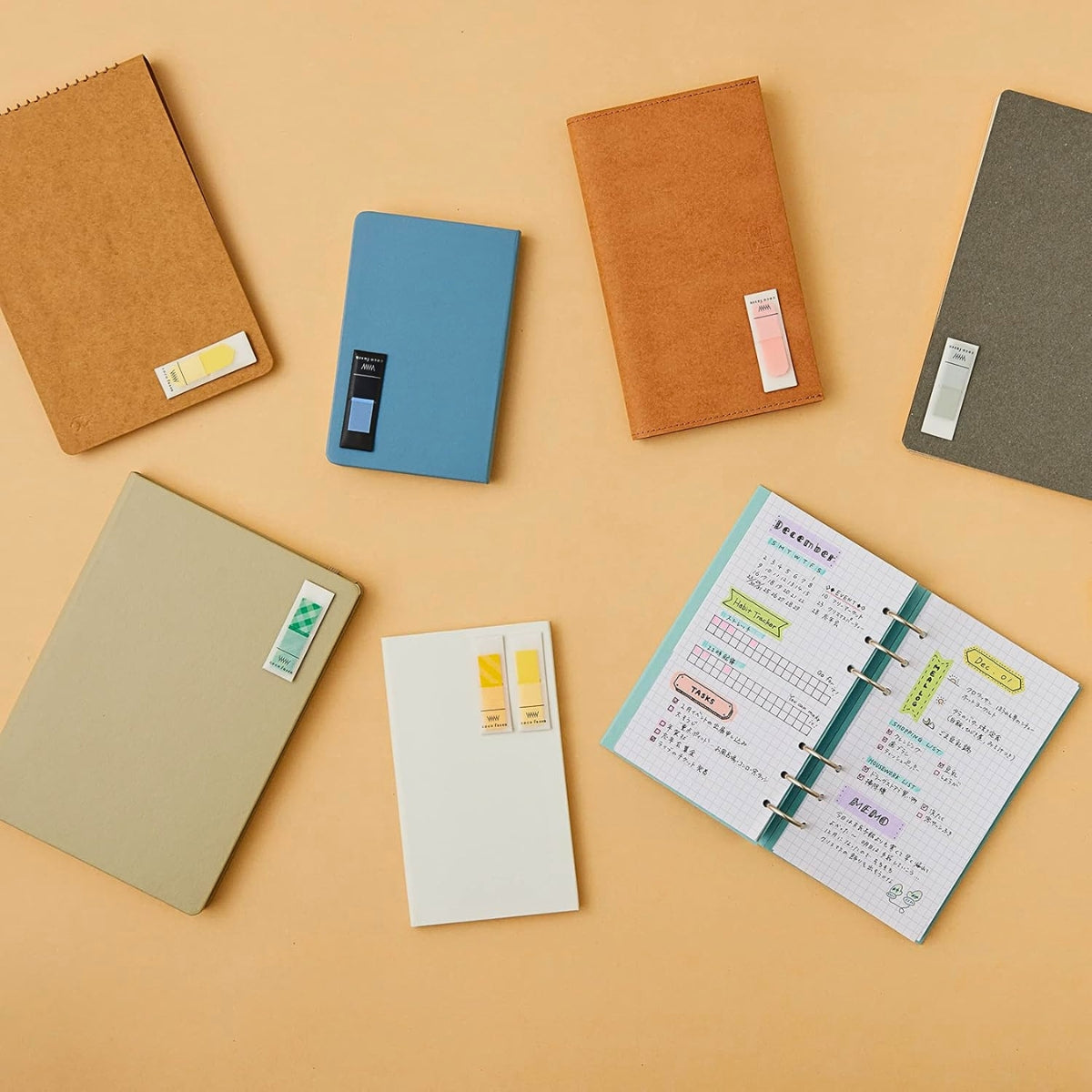 Kanmido Kokofusen Pattern sticky notes arranged on a desk alongside notebooks and stationery.